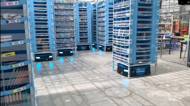 Robot di chuyển kệ hàng theo hệ thống mã vạch trên sàn nhà.